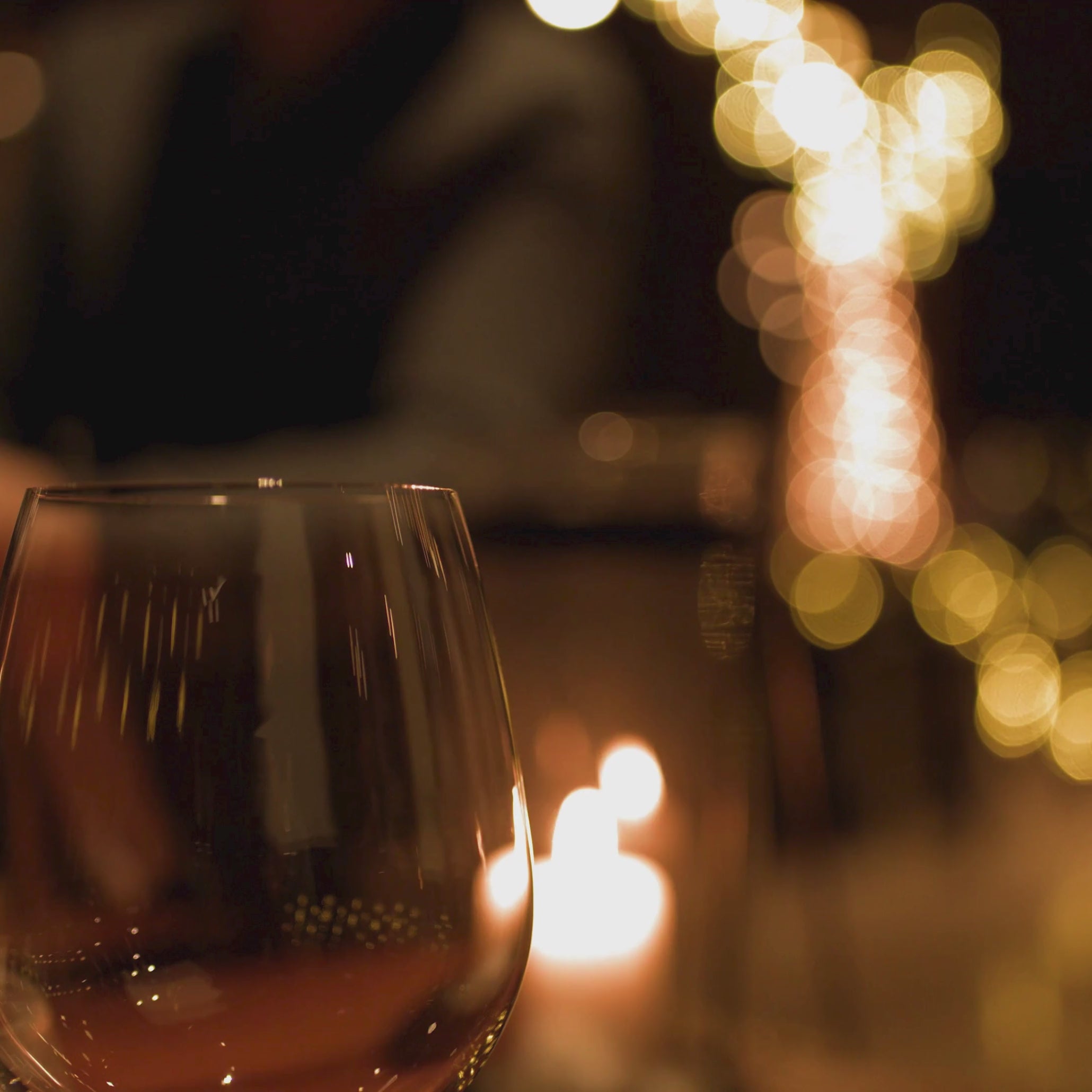 candle flickering in the background at a bar