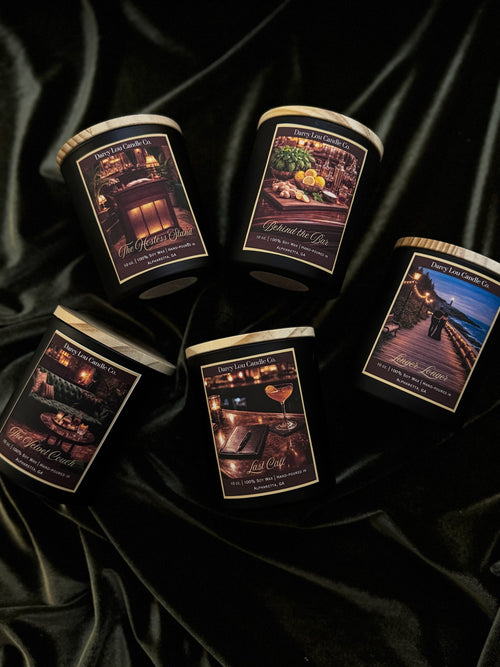 Five candles with scenic labels on a black satin background
